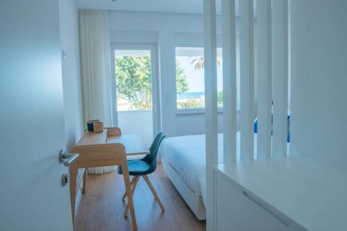a bedroom with a bed and a desk and a table at NEW Estrela da Praceta Apt w/ 3 Suites & Oceanview in Carcavelos