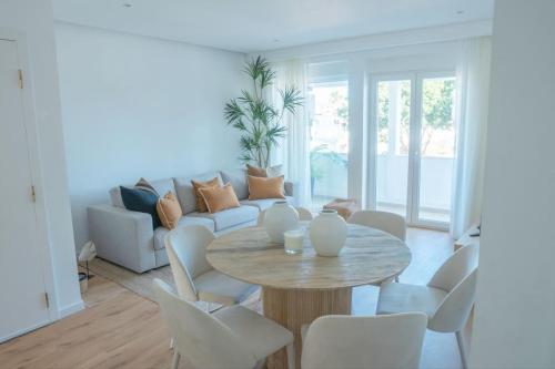 a living room with a table and a couch at NEW Estrela da Praceta Apt w/ 3 Suites & Oceanview in Carcavelos