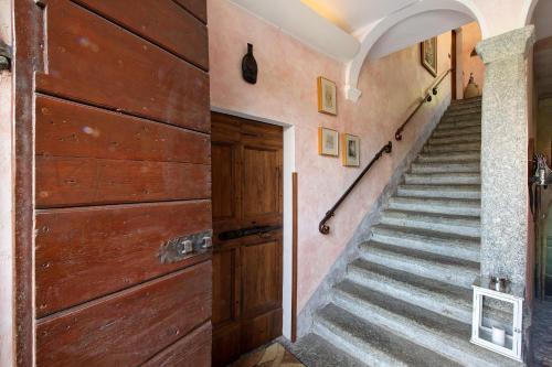 a staircase in a house with a wooden door at Taronico Apartments Heron in Bellagio