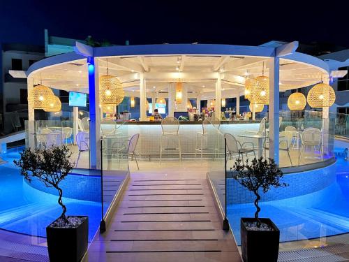 a pavilion with a table and chairs in a pool at Katia Hotel in Ixia