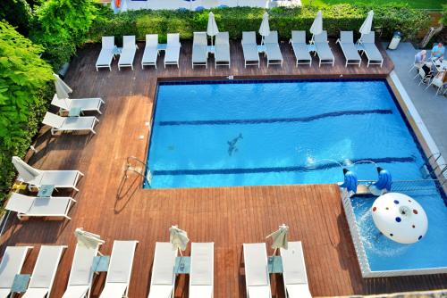 an overhead view of a swimming pool with white chairs at Katia Hotel in Ixia