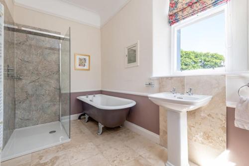 W łazience znajduje się wanna, umywalka i prysznic. w obiekcie Cauldhame House w mieście Dunblane