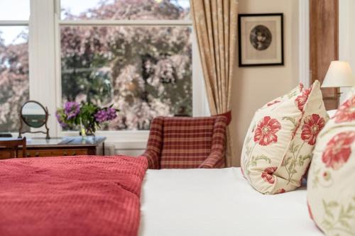 sypialnia z łóżkiem z czerwoną pościelą i oknem w obiekcie Cauldhame House w mieście Dunblane