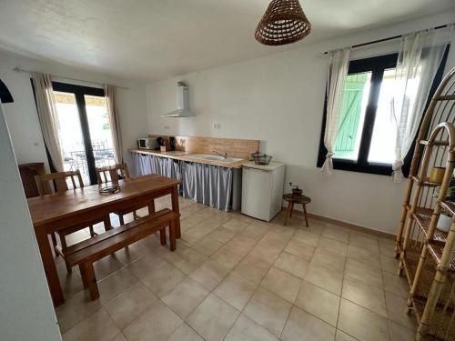 un salon avec une table et une cuisine dans l'établissement Maison à deux pas des plages avec jardin, terrasses et spa., à Mèze