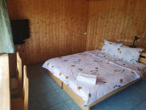 a bedroom with a bed with a wooden wall at Griežto 5 in Zarasai