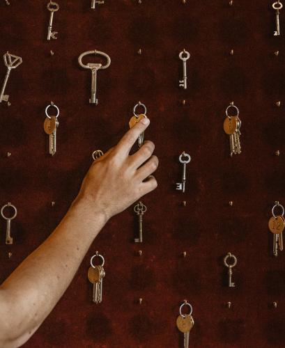 a hand holding up a bunch of keys on a wall at Hotel Slottsvillan in Huskvarna
