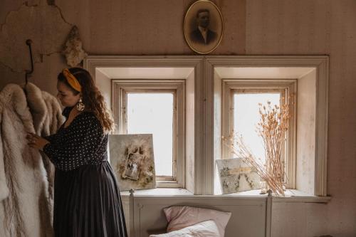 a woman in a dress looking in a window at Hotel Slottsvillan in Huskvarna