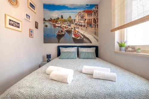um quarto com uma cama com um quadro na parede em Casita São Gonçalinho by Home Sweet Home Aveiro em Aveiro