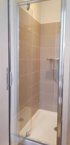 La salle de bains est pourvue d'une douche avec une porte en verre. dans l'établissement Maison Anne face to park in Vernon Giverny, à Vernon