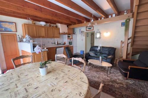sala de estar con mesa y cocina en Binic maison de campagne, en Plourhan