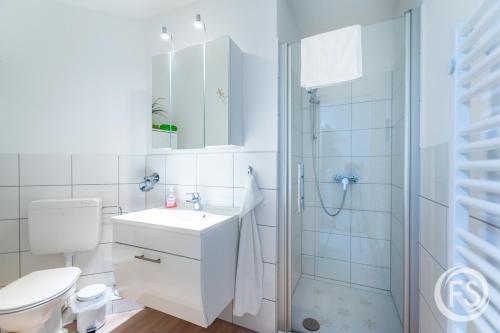 a bathroom with a shower and a toilet and a sink at Strandhotel Whg20 in Dahme