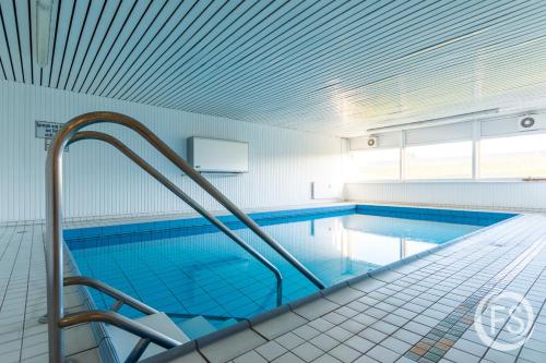 a swimming pool in a building with a ceiling at Strandhotel Whg20 in Dahme