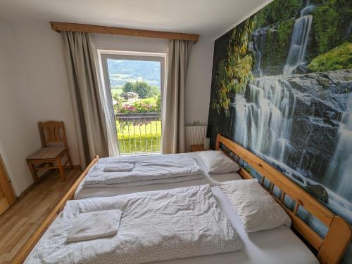 a bedroom with two beds and a large window at Haus Kathan in Kamering