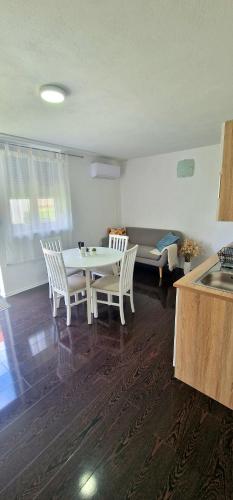 een woonkamer met een tafel en stoelen en een keuken bij New apartment near Plitvice lakes in Smoljanac