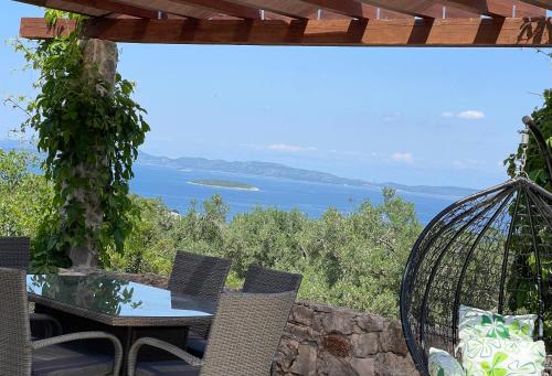 a patio with a table and chairs and a view of the ocean at Holiday House Rusticana Sali, Dugi otok near NP Kornati in Sali