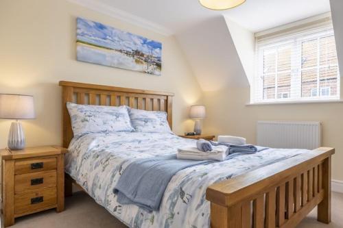 a bedroom with a large bed and a window at The Coach House W in Wells next the Sea