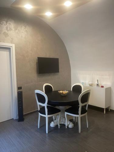 a dining room with a black table and chairs at Plebiscito home in Naples