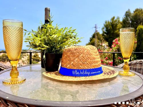 Un sombrero de paja y dos vasos sobre una mesa. en VH CostaBlanca - ZEN, en Fanadix