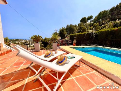 un patio con dos sillas y una piscina en VH CostaBlanca - ZEN, en Fanadix