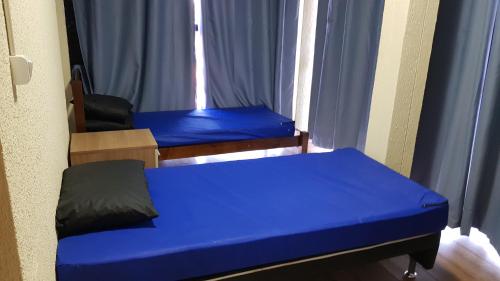 a small room with a blue bed and a window at Triplex de veraneio em Guaratuba in Guaratuba