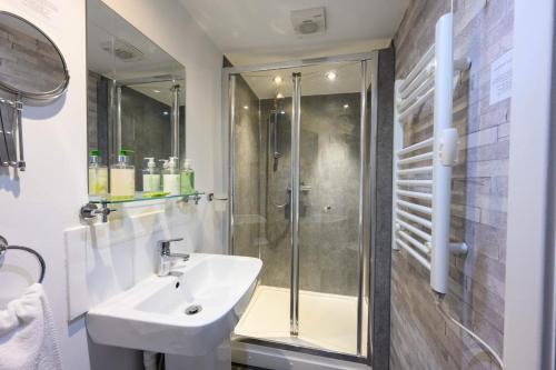 a bathroom with a sink and a shower at Abbey Guest House in Redcar