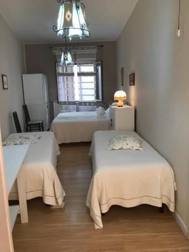 a room with two beds and a table and a window at La Tela Di Penelope in San Marco dʼAlunzio
