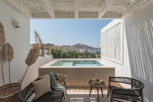 a patio with a pool and chairs and a table at Hotel Senia - Onar Hotels Collection in Naousa