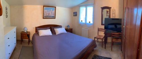 1 dormitorio con 1 cama y TV de pantalla plana en Binic maison de campagne, en Plourhan