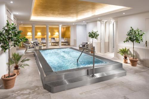 uma grande piscina num quarto com plantas em Clarion Grandhotel Zlaty Lev em Liberec