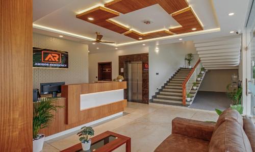 a living room with a couch and a staircase at Treebo Amigos Residency Cochin Airport Hotel in Cochin