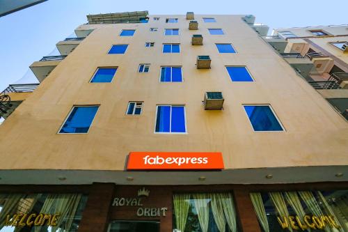 un edificio alto con ventanas azules y un cartel en él en FabExpress Royal Orbit en Nueva Delhi