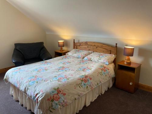 a bedroom with a bed and a chair and two lamps at Radharc Na Ceibhe B&B H91 V0Y3 in Inis Mor