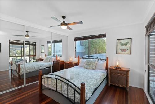 a bedroom with two beds and a ceiling fan at 19a George Nothling Drive in Point Lookout