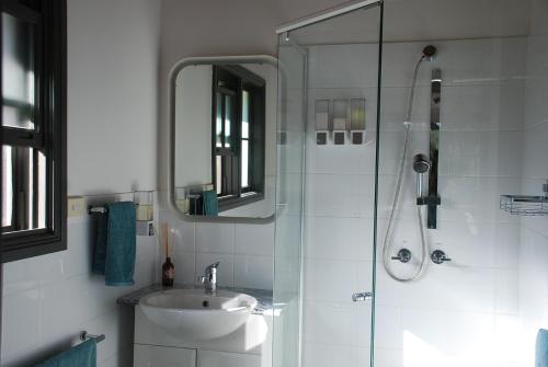 a bathroom with a sink and a shower with a mirror at The Bower at Wildside Sanctuary in Bilpin