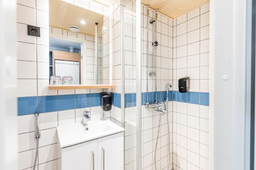 a bathroom with a shower and a sink and a mirror at Sporttihotelli Pihkala in Vierumäki