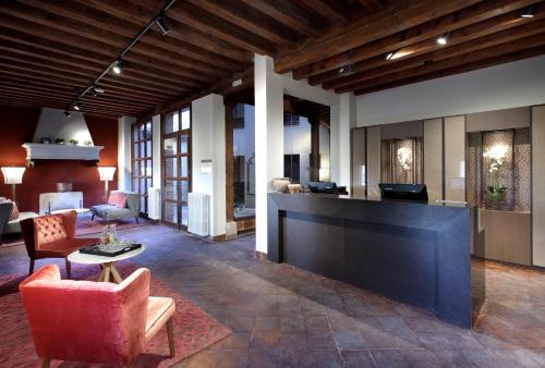 a lobby with a reception desk and a living room at Exe Casa de Los Linajes in Segovia