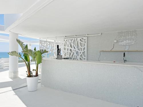 cocina blanca con encimera y planta en Global Properties, Apartamento para 5 personas con terraza y vistas a la piscina, en Canet de Berenguer