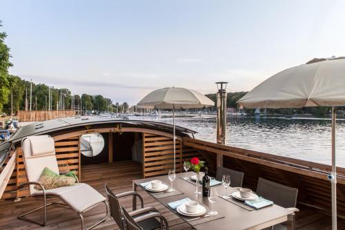 une table avec des chaises et un bateau dans l'eau dans l'établissement Independence One, à Berlin