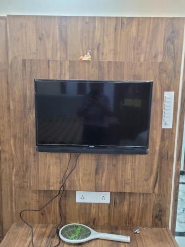 Elle comprend une télévision à écran plat installée au-dessus d'un mur en bois. dans l'établissement Gupta Residence., à Dhanbād