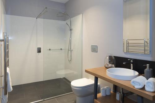 La salle de bains est pourvue d'une douche, de toilettes et d'un lavabo. dans l'établissement Roxburgh House Apartments, à Hobart