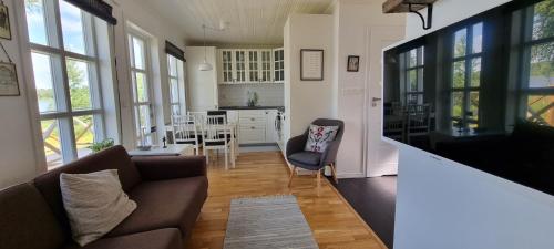 a living room with a couch and a table at Mysig stuga med sjötomt, nära Järvsöbacken in Järvsö