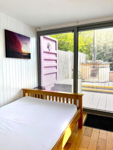 a bedroom with a bed and a large window at Purple CargoPod at Lee Wick Farm Cottages & Glamping in Clacton-on-Sea