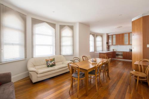 - un salon avec une table et un canapé dans l'établissement Roxburgh House Apartments, à Hobart