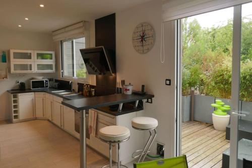 une cuisine avec un comptoir et une grande fenêtre dans l'établissement MAISON DE VILLE PRES DE LA PLAGE, à Arcachon