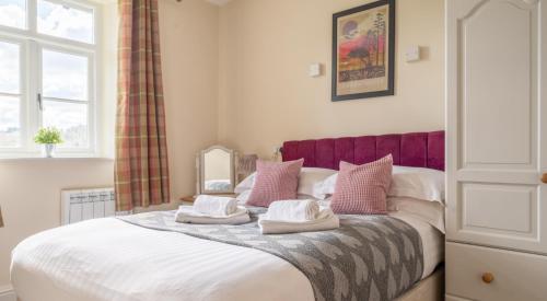 a bedroom with a bed with two pillows on it at Thirlmere in Sawrey