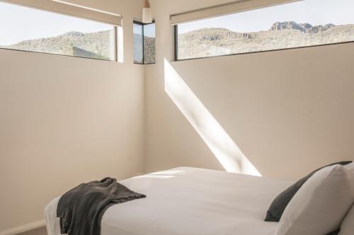 a bedroom with a bed and two windows at Villa View in Halls Gap