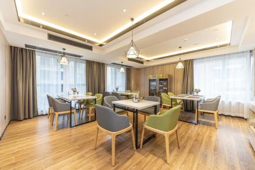 een restaurant met tafels, stoelen en ramen bij Morning Hotel, Zhuzhou Manhattan Commercial Plaza in Zhuzhou