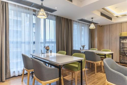 een conferentiezaal met tafels, stoelen en ramen bij Morning Hotel, Zhuzhou Manhattan Commercial Plaza in Zhuzhou