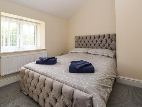 ein Schlafzimmer mit einem großen Bett mit blauen Kissen darauf in der Unterkunft Cae Iocyn in Wrexham