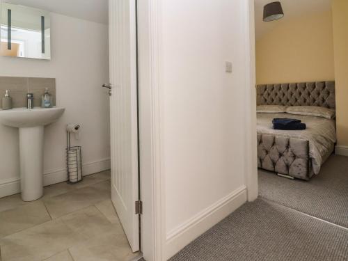 ein Bad mit einem Bett und einem Waschbecken in einem Zimmer in der Unterkunft Cae Iocyn in Wrexham